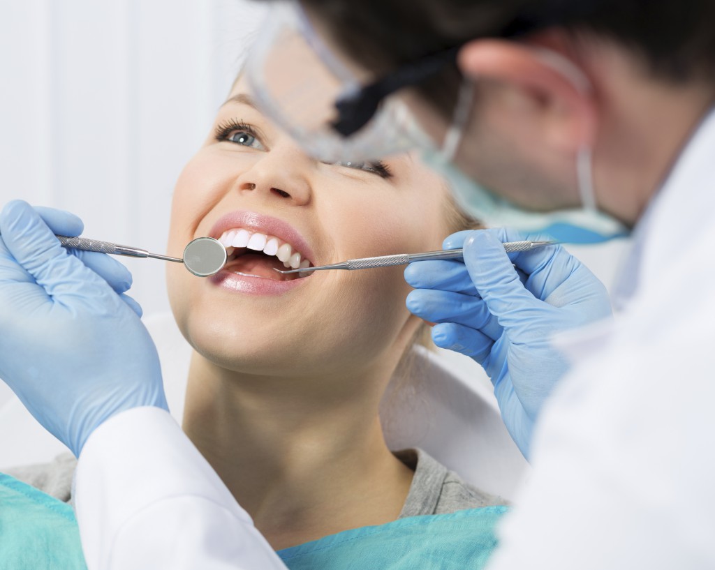 Regular dentist visit. Caries cure. Young woman visiting dentist